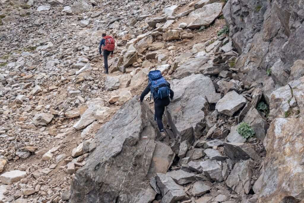 Zwei Wanderer auf Steinweg, eine nutzt Hände - GR 52 Wanderung Alpen Frankreich Mercantour