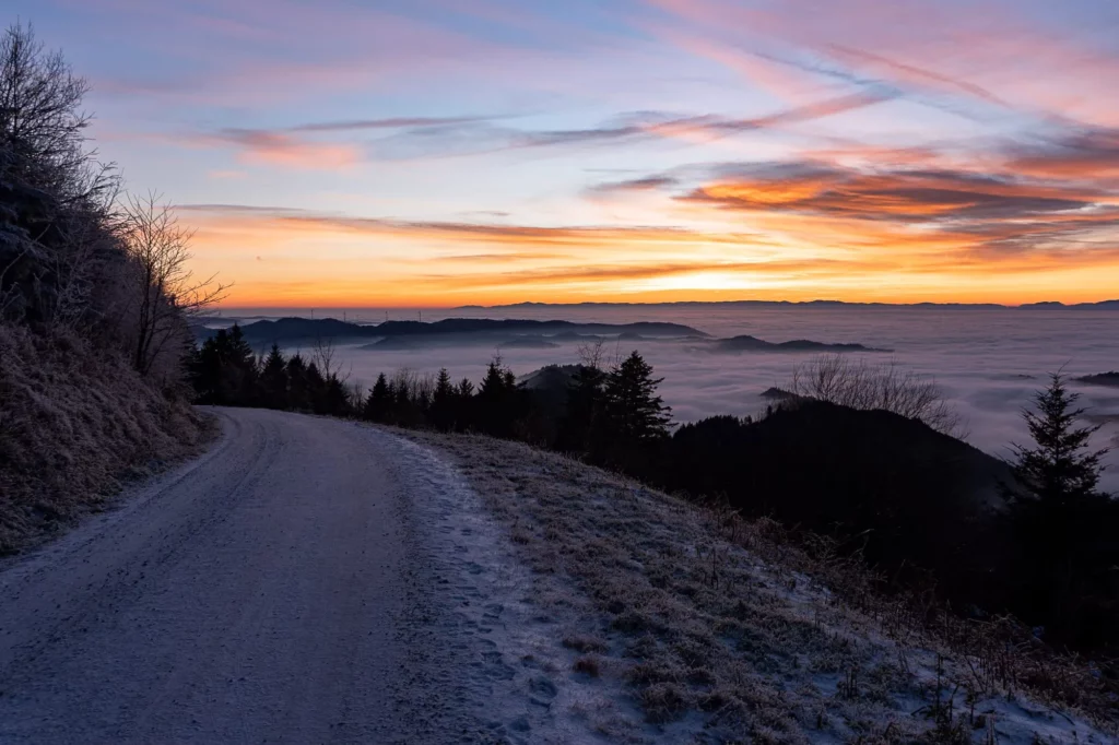 Wanderweg bei rotem Abendhimmel und Nebel 