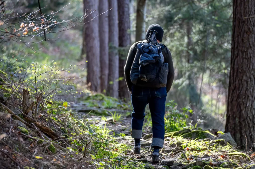 Wanderer geht bergauf auf Pfad bei Sonnenschein
